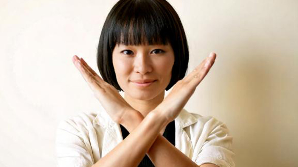 手でバツを作る女性