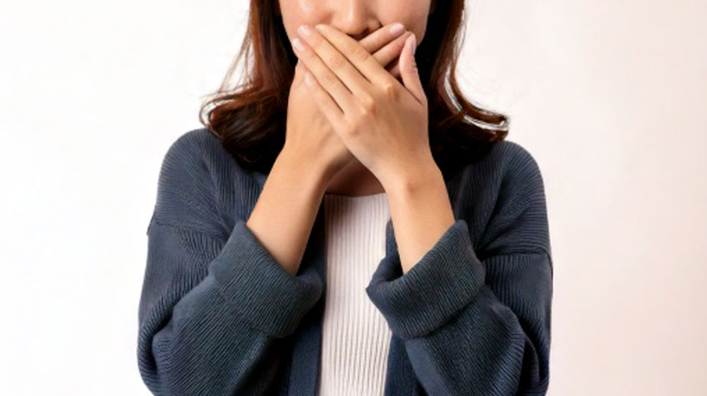 口を隠す女性