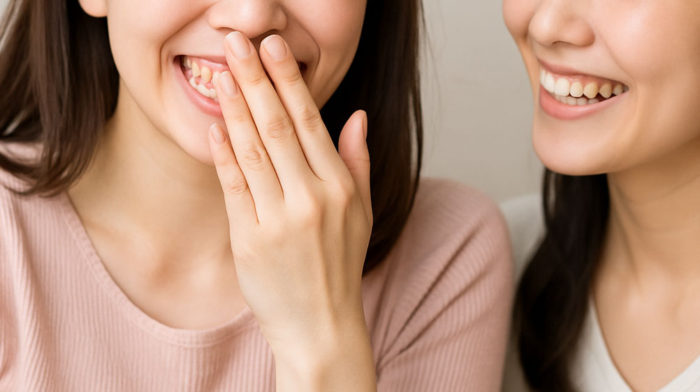 笑いながら口を覆う女性